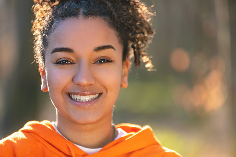 Girl with healthy gums smiling outside