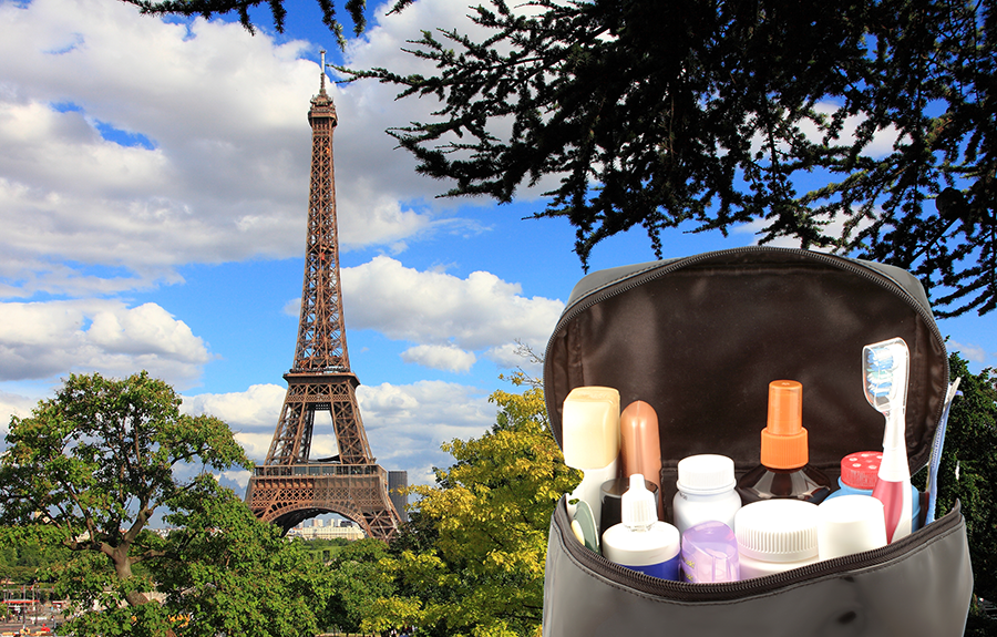 A travel case with a covered toothbrush with the Eiffel Tower in the background.