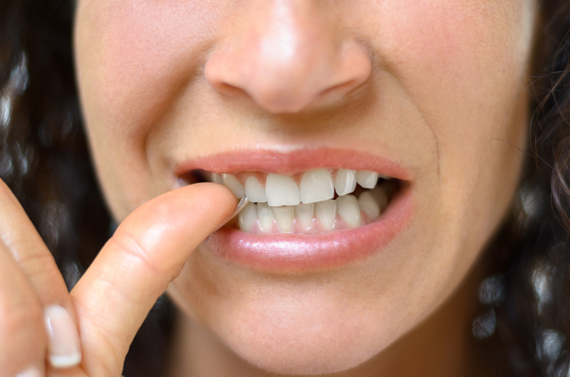 Girl pointing to tooth at dentist