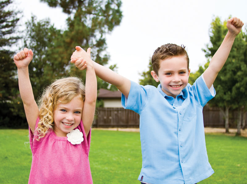 A young girl and boy playing outside.